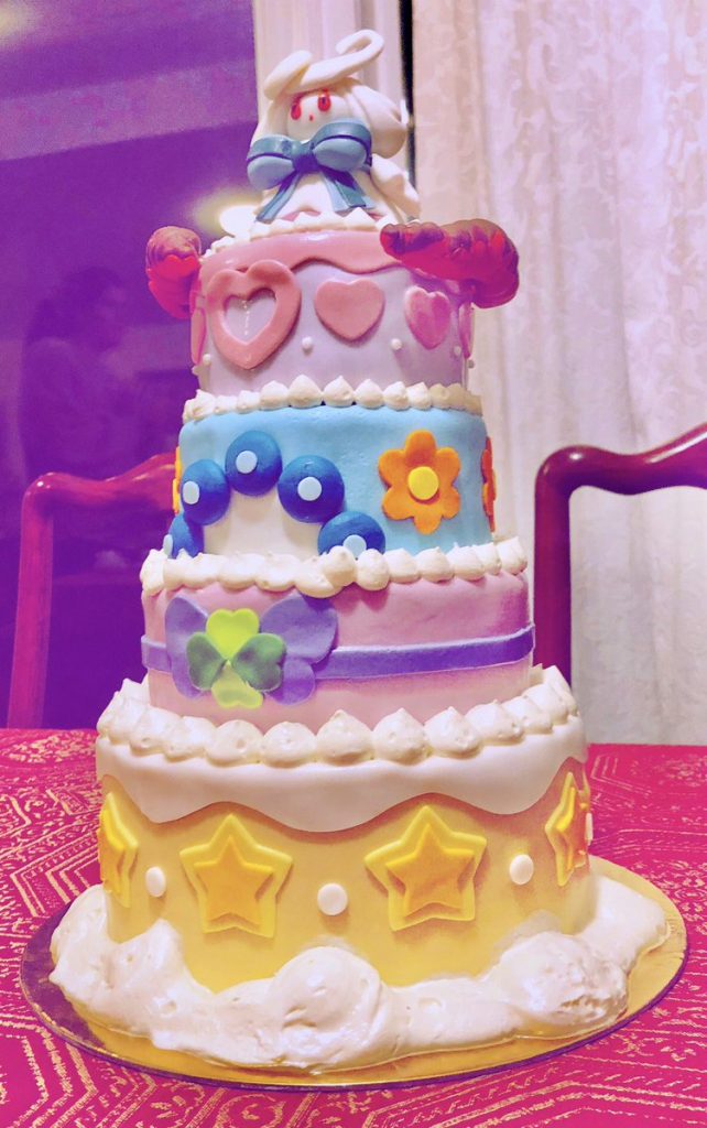 la torta di Alcremie con gli ultimi dettagli: nuvolette e filtro viola